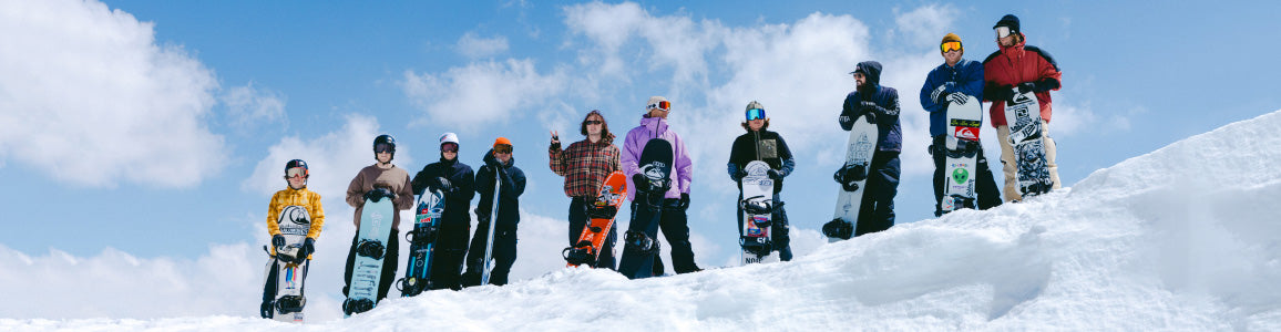 Groep snowboarders met hun boards op een besneeuwde bergkam